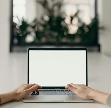 image shows hands typing on a laptop