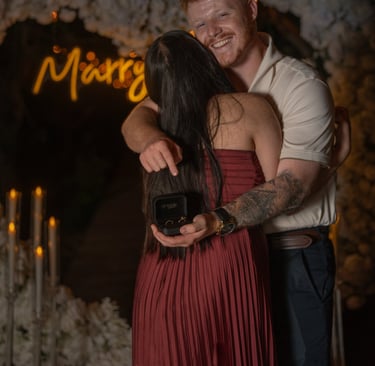 a man and woman embracing in front of a neon sign
