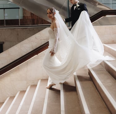 a bride and groom walking down a flight of stairs