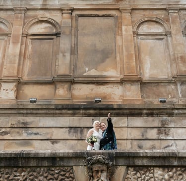 a bride and groom standing on a balcony