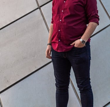 Wide picture of Manuel Tirado, wearing a red shirt and black pants.