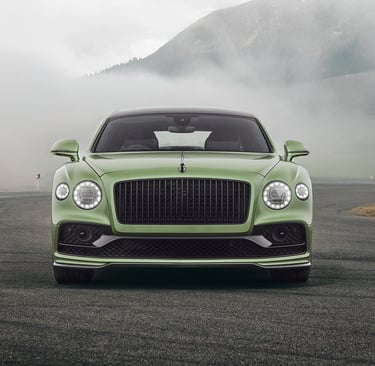 a green bentley flying spur in the swiss mountains