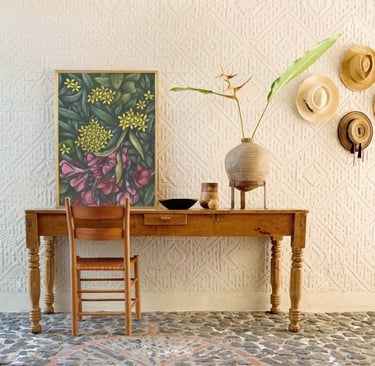 Rustic home interior with a wooden table and a chair and a botanical hand-drawn framed art print