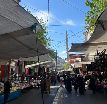 a street market scene with a lot of people walking around