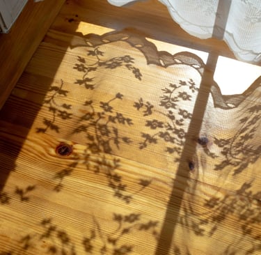 Soft sunlight casting curtain shadows, capturing Jahida's childhood memory of magical sunlit dust.