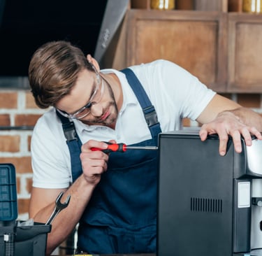 a man in a blue apron and glasses is working on a computer