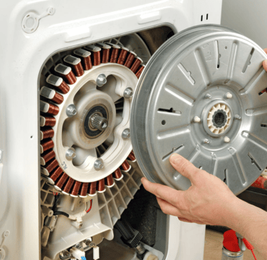 a person is fixing a motor cycle in a washing machine