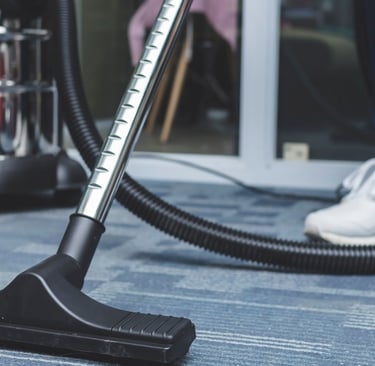 a person is cleaning a carpet with a vacuum