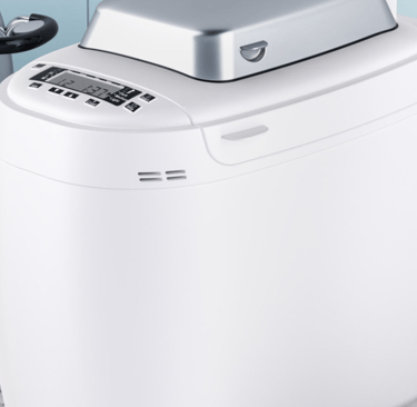 a white bread maker with a knife and knife on a counter
