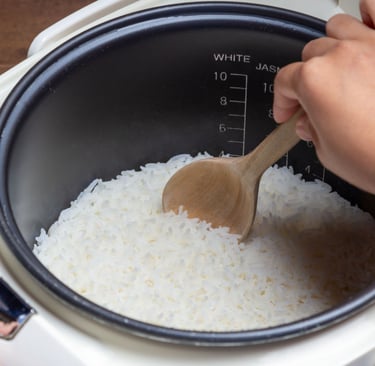 a person is cooking rice in a rice cooker