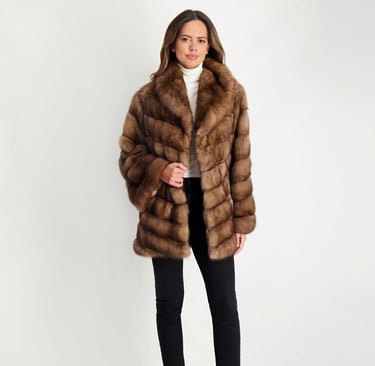 a woman in a brown gorski fur coat and black pants