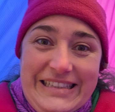 Kayla Brooks standing between hot air balloons and looking excited