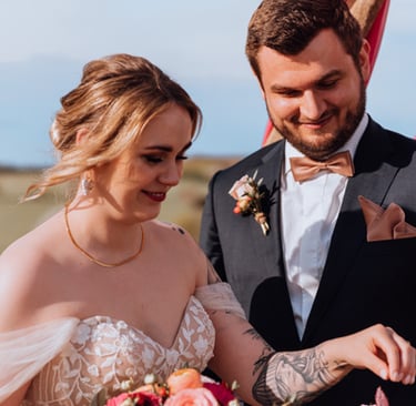 Ringtausch. die tätowierte Braut greift nach dem Ehering um diesen ihrem Bräutigam anzustecken. er lächelt glücklich