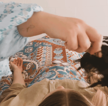 kinesiologist using shamanic rattle for sound healing over client