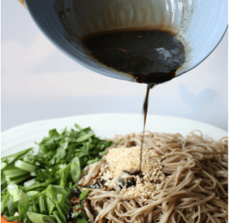 pouring sauce on Potluck Soba Salad