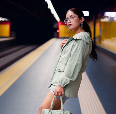 a woman in a green coat and heels is holding a purse