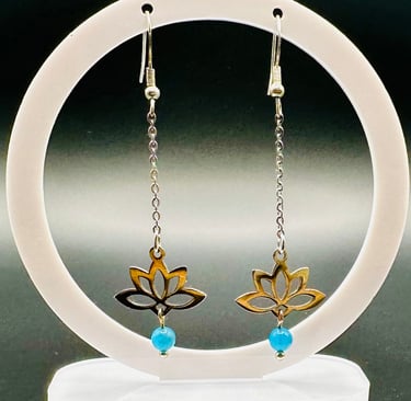 a pair of earrings with a gold and blue flower