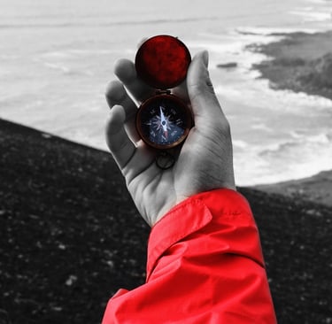 a person holding a compass on a beach