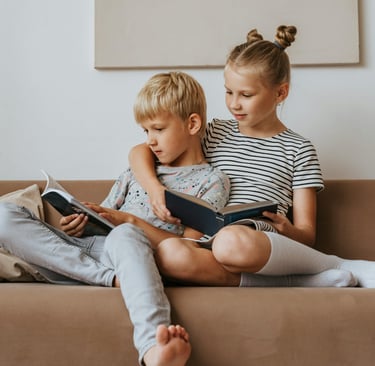 two children on a couch with books