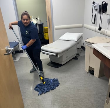a woman in a hospital room cleaning a floor