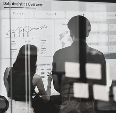 a group standing in front of a white board discussing a slide titled Data Analytics Overview