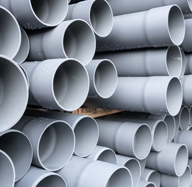 a stack of plastic pipes and pipes in a pile