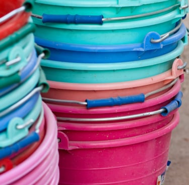 a bunch of buckets with different colored plastic buckets