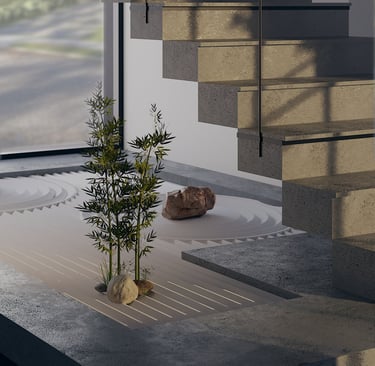 Artificial bamboo and stones arranged in a sandy bed under an indoor staircase.