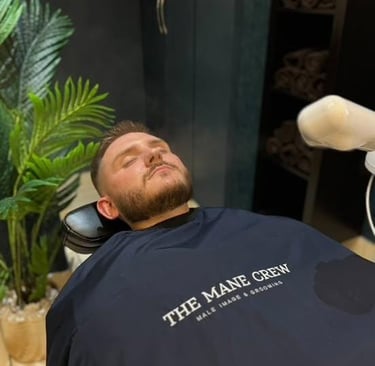 Man lying on a barber shair at the mane crew barbers