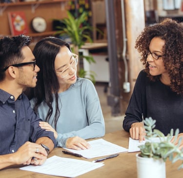 Home buyers signing a real estate offer with agent