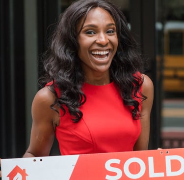 Professional real estate agent holding a sold sign