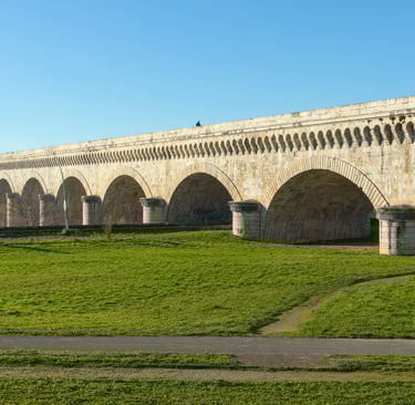 a bridge spanning a river with a bridge in the background