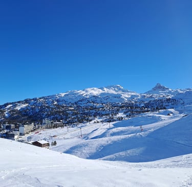 a person on a ski slope with a mountain in the background