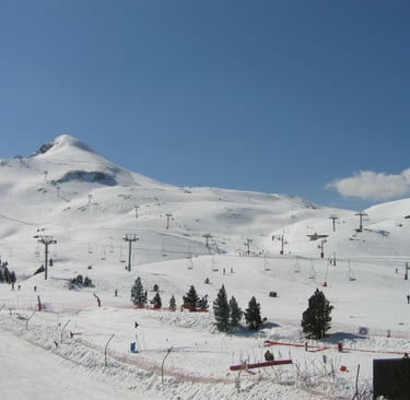 a ski slope with a ski lift in the background