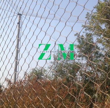 Durable stainless steel wire rope mesh fencing installed outdoors for zoo enclosures and safety netting.