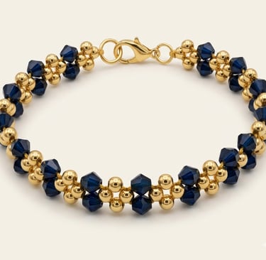 Elegant gold bead and blue sapphire crystal bracelet with a secure lobster clasp closure.