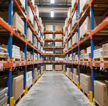 Warehouse aisle with boxes on tall industrial pallet racking systems for storage and distribution.