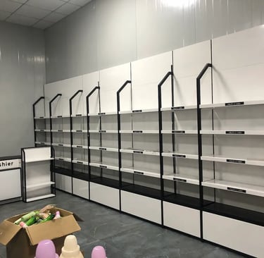 Empty white and black cosmetic display shelves and cashier counter in a retail skin care store.