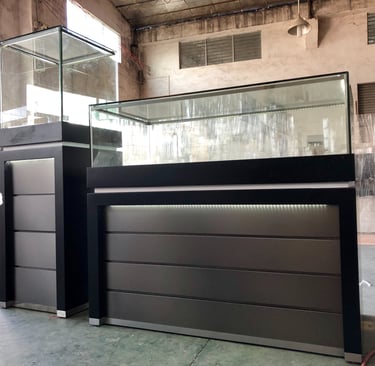 Modern black jewelry display cases with LED lighting and glass showcases in a retail furniture warehouse.