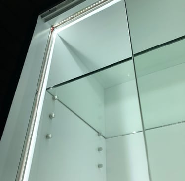 A modern glass display cabinet with integrated LED strip lighting on white shelves.