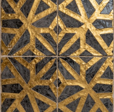 Close-up artistic photography of a North African / Moroccan geometric mosaic tile detail featuring gold and dark gray textures. Elegant and sophisticated minimalist composition.