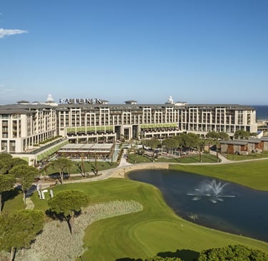 Aerial view of Cullinan Belek luxury resort featuring a golf course, lake, and Mediterranean beachfront.