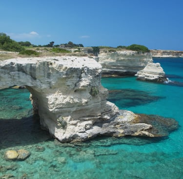 White limestone cliffs and natural arch over crystal clear turquoise sea at Torre dell'Orso, Puglia.