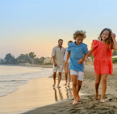 A happy family with young children enjoys a sunset walk on a sandy beach