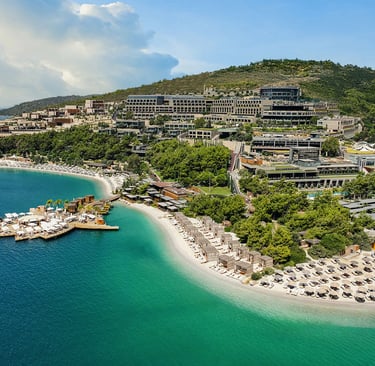 Aerial view of a luxury beachfront resort in Bodrum with turquoise water and sandy beaches.