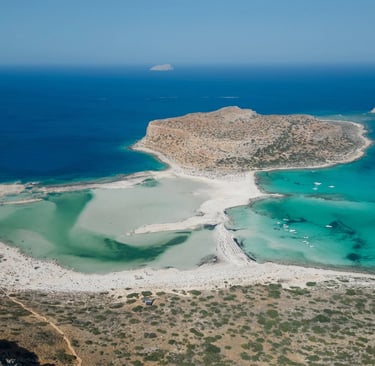 Aerial view of Balos Lagoon in Crete featuring turquoise waters and white sand beach.