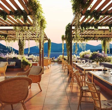 Luxury rooftop restaurant at Hotel Falkensteiner Lake Garda with wooden pergolas, hanging greenery.