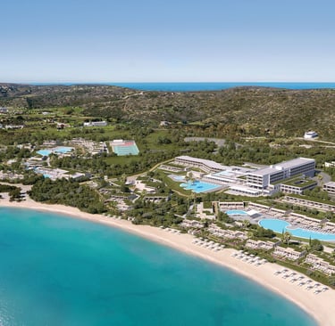 Aerial view of a Ikos featuring multiple swimming pools, modern architecture, and a turquoise ocean.