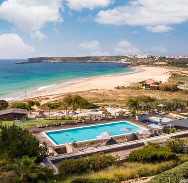 Luxury resort Martinhal Sagres with an outdoor swimming pool overlooking a sandy beach and ocean