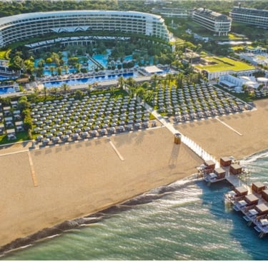 Maxx Royal luxury resort with swimming pools, private cabanas, and a wooden pier over the ocean.
